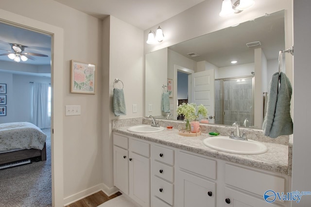 bathroom featuring a shower with door, vanity, and ceiling fan