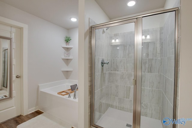 bathroom featuring hardwood / wood-style flooring and separate shower and tub