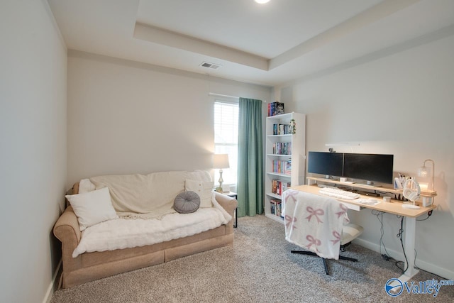 carpeted home office with a tray ceiling