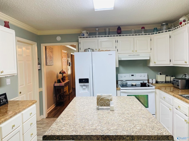 kitchen with white appliances, hardwood / wood-style floors, ornamental molding, a center island, and a textured ceiling