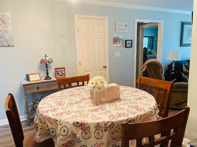 dining area featuring wood-type flooring and ornamental molding