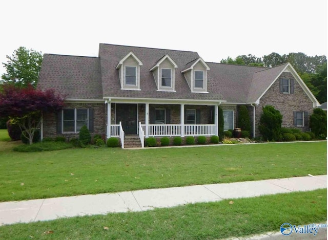 cape cod home with roof with shingles, a porch, and a front lawn