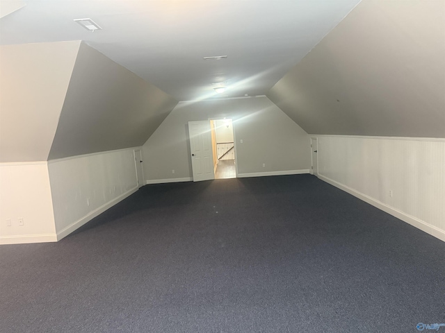 bonus room with lofted ceiling and baseboards