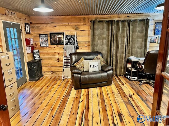 living area with hardwood / wood-style flooring, wood walls, and wood ceiling