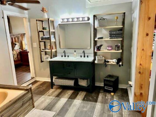 bathroom featuring hardwood / wood-style flooring, vanity, a washtub, and ceiling fan