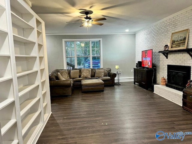 living room featuring ceiling fan, brick wall, dark hardwood / wood-style floors, and a brick fireplace