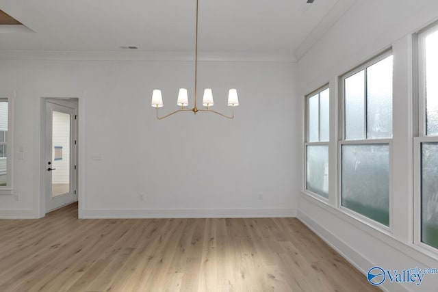 unfurnished dining area with a notable chandelier, light wood finished floors, visible vents, ornamental molding, and baseboards