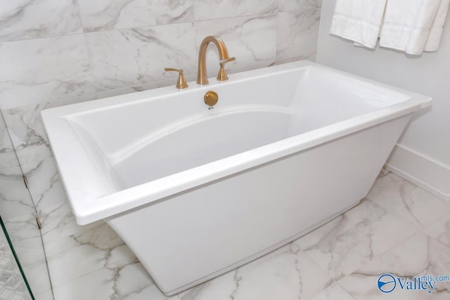 bathroom featuring a freestanding tub and marble finish floor