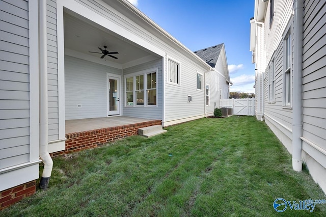 view of yard featuring a patio, ceiling fan, a gate, fence, and central air condition unit