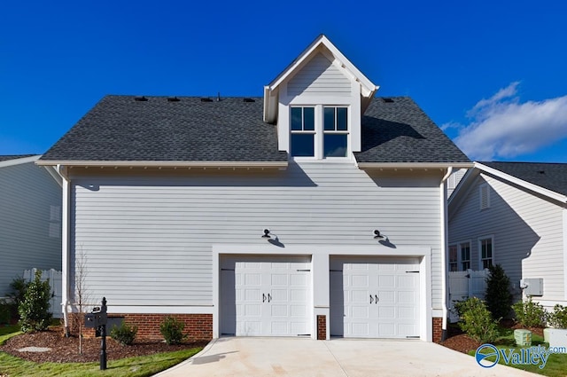 view of front of property with driveway and roof with shingles