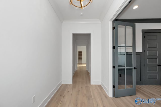 hall featuring ornamental molding, light wood-style flooring, and baseboards