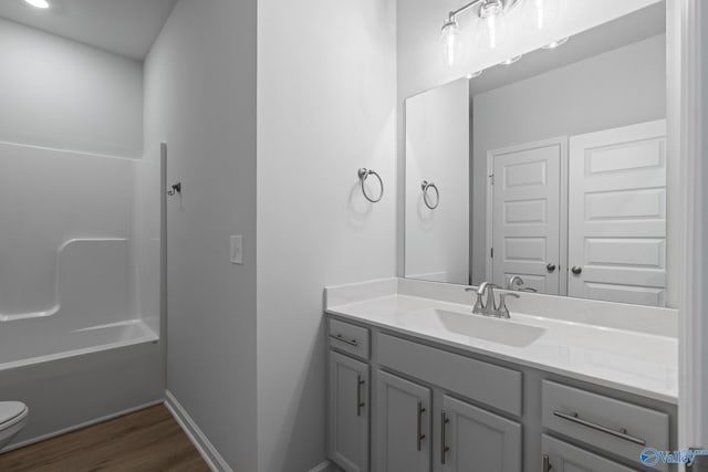 full bathroom with vanity, toilet, wood-type flooring, and shower / tub combination