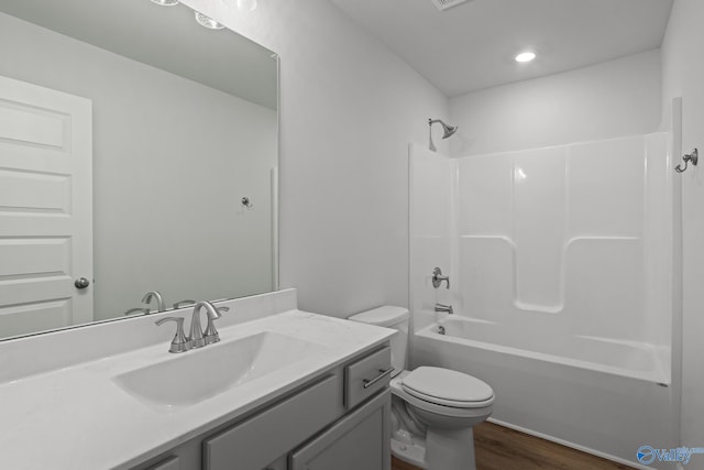 full bathroom featuring wood-type flooring, vanity, toilet, and tub / shower combination