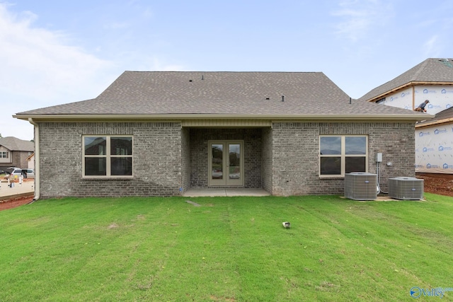 rear view of house with a lawn, french doors, cooling unit, and a patio