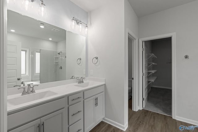 bathroom featuring hardwood / wood-style flooring, vanity, toilet, and walk in shower