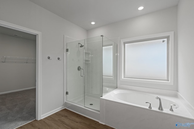 bathroom with hardwood / wood-style floors and separate shower and tub