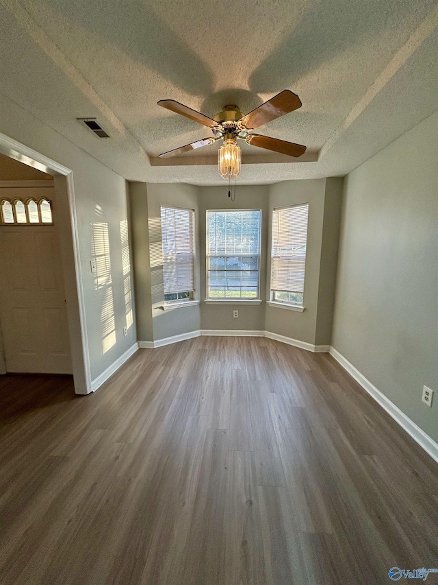 unfurnished room with ceiling fan, wood-type flooring, and a textured ceiling