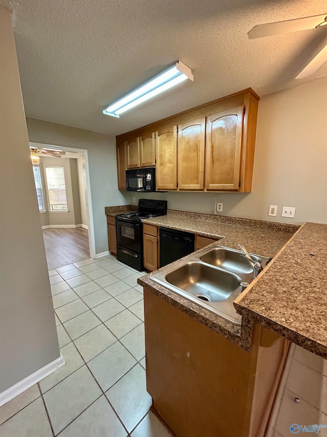 kitchen featuring sink, light tile patterned floors, black appliances, and ceiling fan