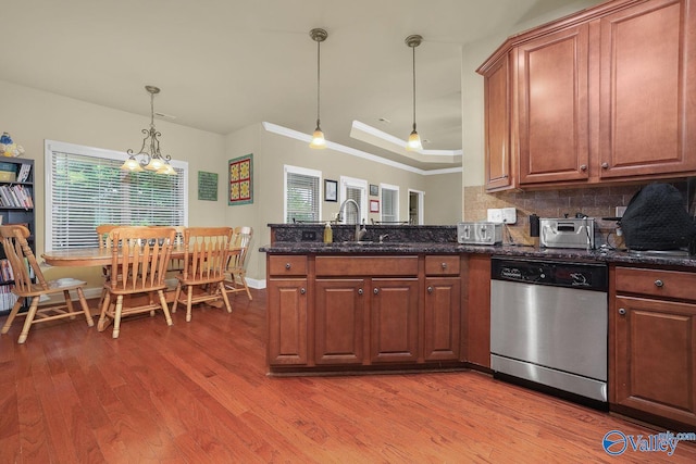 kitchen featuring sink, tasteful backsplash, decorative light fixtures, dark stone countertops, and stainless steel dishwasher