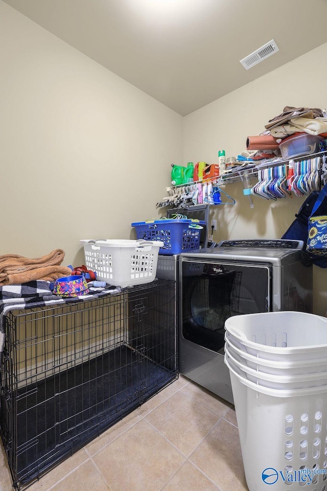 laundry room featuring independent washer and dryer and light tile patterned flooring