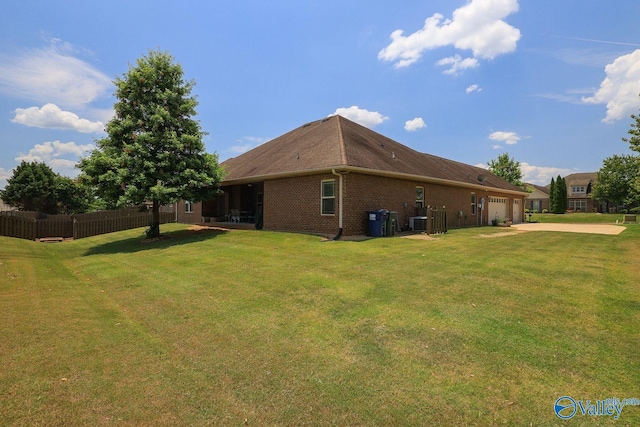 view of side of property featuring cooling unit, a yard, and a garage