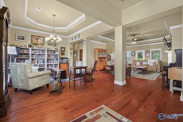 living room featuring a tray ceiling, ceiling fan with notable chandelier, and hardwood / wood-style flooring