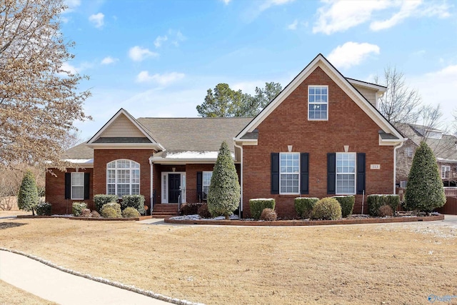 traditional-style house featuring a front yard and brick siding