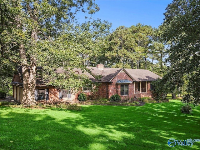 single story home with a front lawn, a chimney, and brick siding