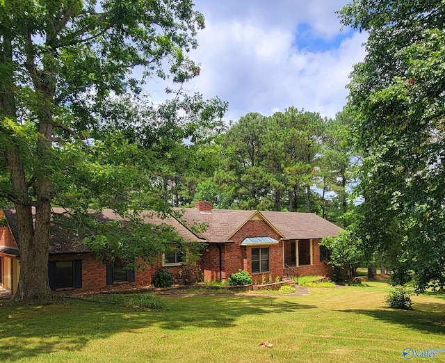 single story home with a chimney, a front lawn, and brick siding