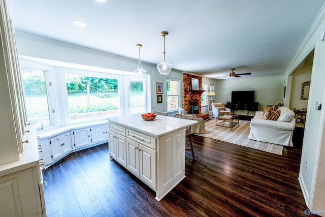 218 Beaver Run Dr, Madison, AL 35758 - kitchen featuring a brick fireplace, a ceiling fan, white cabinetry, dark wood-type flooring, and a breakfast bar area