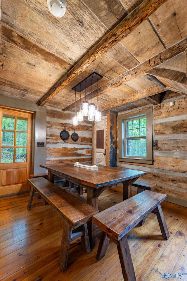 dining area featuring wooden walls, wooden ceiling, wood-type flooring, and beam ceiling