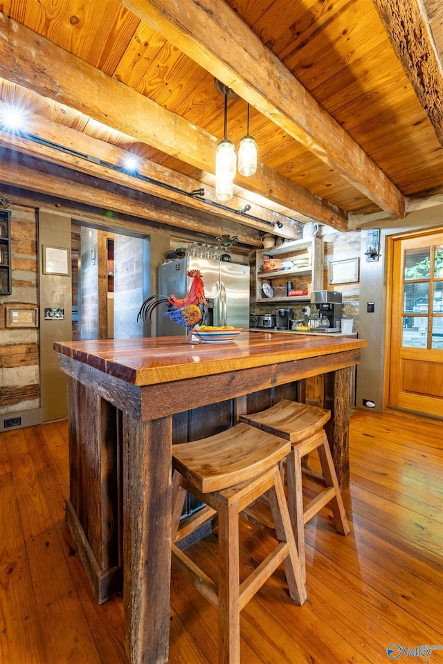 bar featuring stainless steel fridge, beam ceiling, hardwood / wood-style flooring, and wooden ceiling