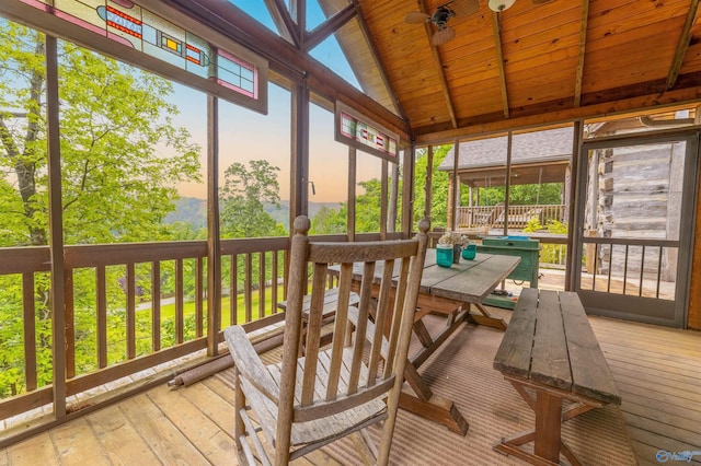 sunroom / solarium featuring vaulted ceiling with beams, a deck, hardwood / wood-style flooring, and wooden ceiling