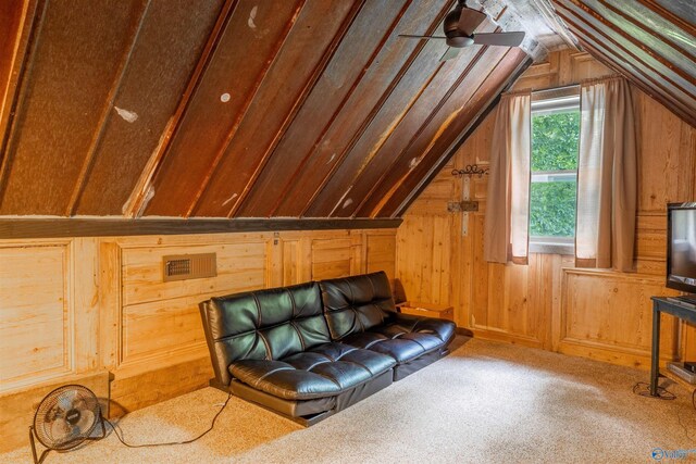 unfurnished room with vaulted ceiling, wood walls, and carpet flooring