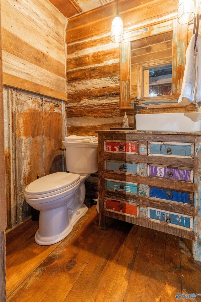 half bath featuring vanity, toilet, and hardwood / wood-style floors