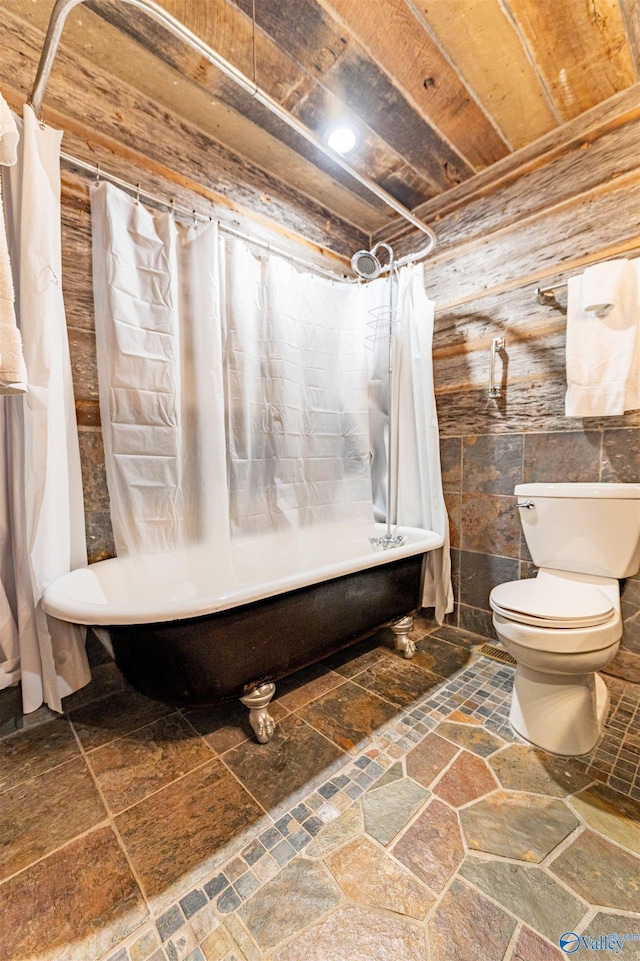 full bathroom featuring wooden ceiling, shower / bath combo with shower curtain, toilet, and stone tile floors