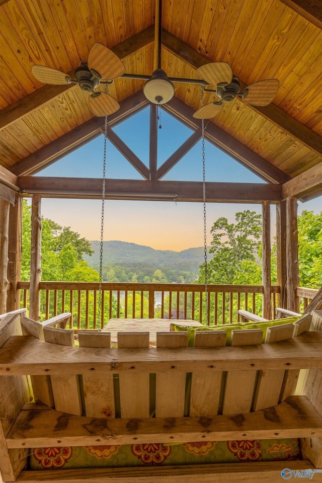 deck at dusk with ceiling fan, a mountain view, and a gazebo