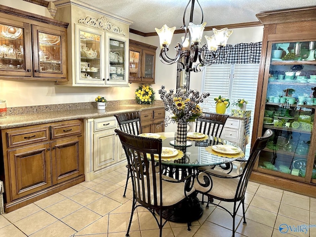 dining area with an inviting chandelier, light tile patterned floors, crown molding, and a textured ceiling