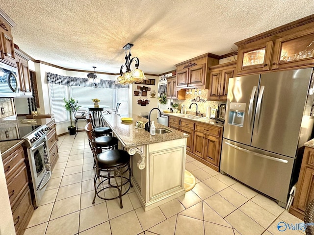 kitchen featuring light tile patterned floors, stainless steel appliances, and a sink