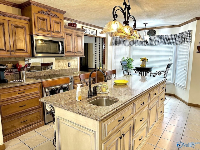 kitchen featuring light tile patterned floors, stainless steel microwave, crown molding, range, and a sink