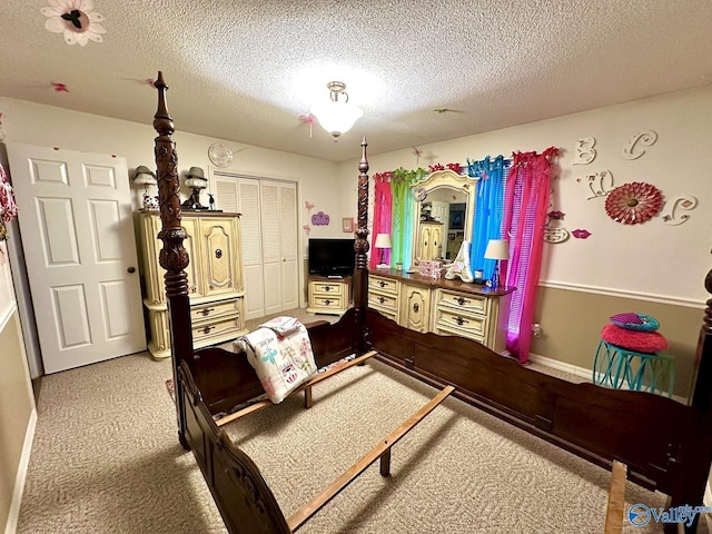 bedroom featuring a textured ceiling, a closet, light colored carpet, and baseboards