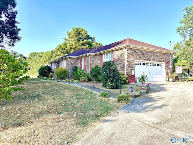 view of front of property with driveway, a front yard, brick siding, and a garage