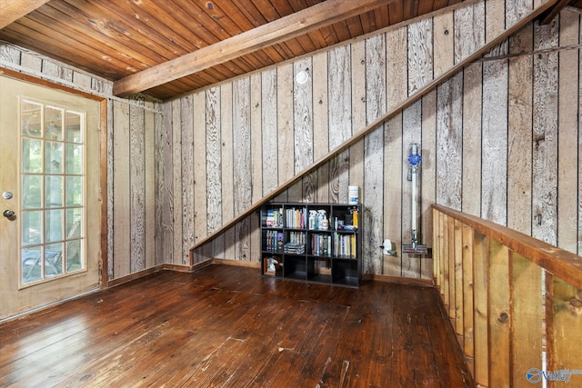 unfurnished living room with beam ceiling, wood-type flooring, and wooden ceiling