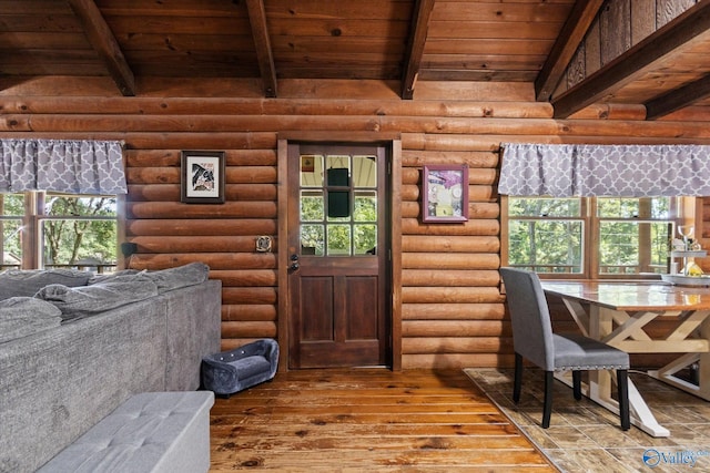 interior space with hardwood / wood-style floors, wooden ceiling, rustic walls, and beamed ceiling