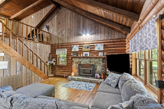 living room with high vaulted ceiling, wood-type flooring, a stone fireplace, wooden ceiling, and beamed ceiling