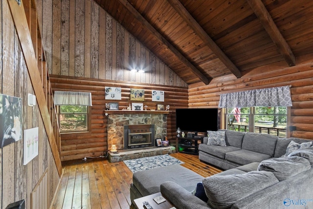 living room featuring beam ceiling, a stone fireplace, high vaulted ceiling, and light hardwood / wood-style flooring