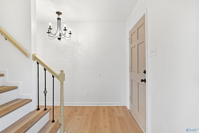 foyer entrance with an inviting chandelier and hardwood / wood-style floors