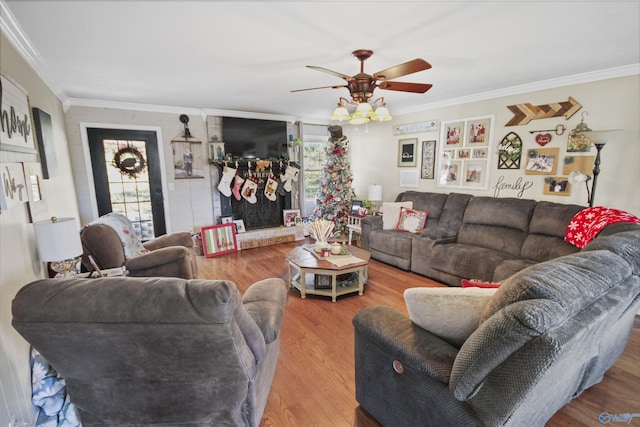 living room featuring hardwood / wood-style floors, ceiling fan, and crown molding