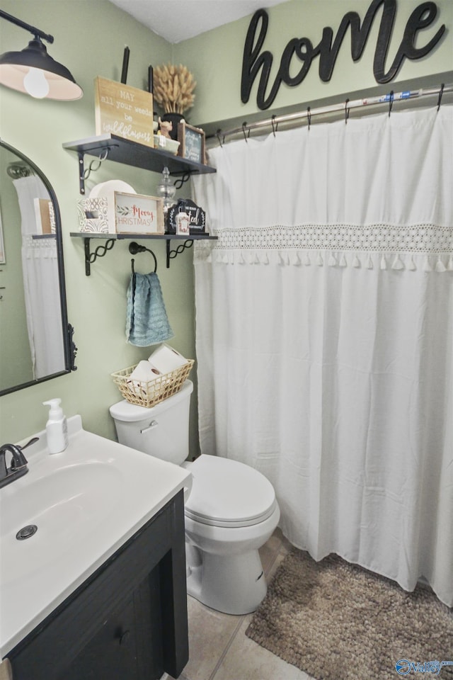 bathroom with tile patterned flooring, vanity, and toilet