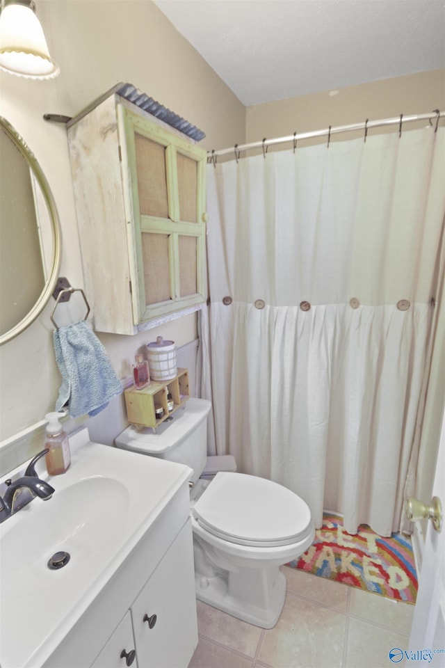 bathroom with tile patterned flooring, vanity, and toilet